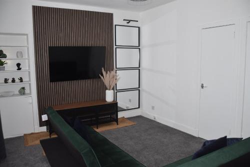 a living room with a couch and a television at 1 Bedroom Flat in Dundee in Dundee
