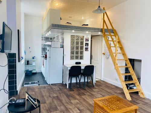 une cuisine avec une table et deux chaises et une échelle dans l'établissement Studio Saint Denis, à Lagny-sur-Marne
