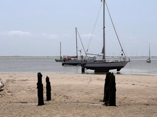 two boats are docked on a beach with poles at Strandschönheit in Wangerooge