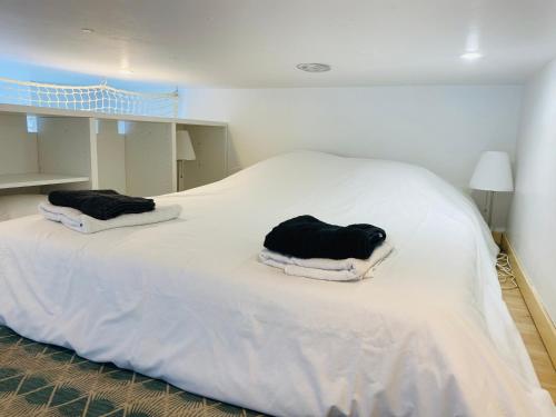 un lit blanc avec deux oreillers dessus dans l'établissement Studio Saint Denis, à Lagny-sur-Marne