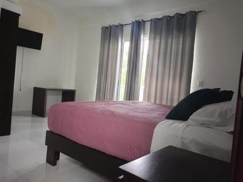 een slaapkamer met een groot bed en een raam bij HOKAB in Cenote Azul
