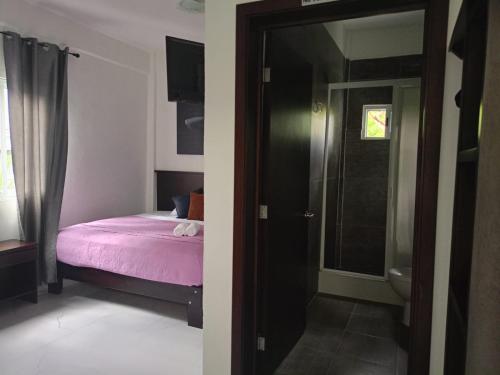 een slaapkamer met een bed en een deur naar een badkamer bij HOKAB in Cenote Azul