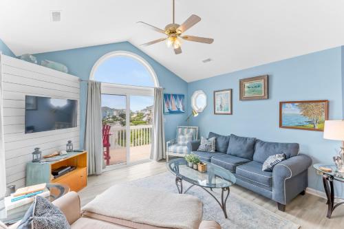 a living room with a couch and a tv at Lowe Tide in North Topsail Beach