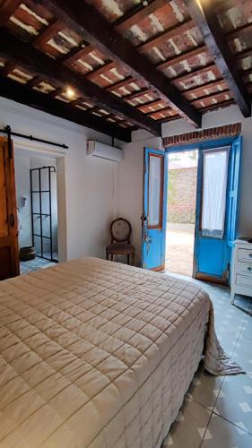 查斯科穆斯的住宿－La Botica de 1852 Hotel，一间卧室设有一张大床和蓝色的门