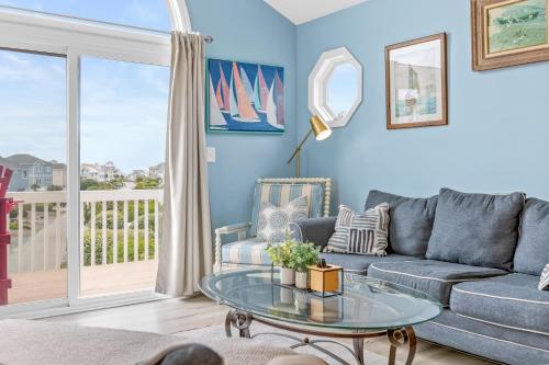 a living room with a couch and a glass table at Lowe Tide in North Topsail Beach
