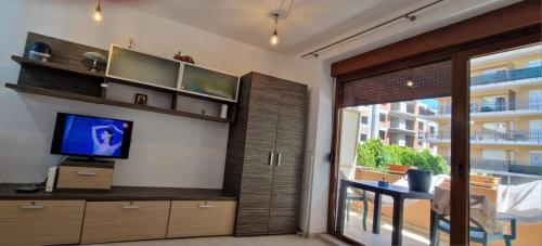 a living room with a tv and a table and a window at Lala's sweet nest by the sea side in Neptun