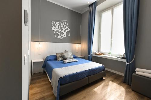 - une chambre avec un lit bleu et une fenêtre dans l'établissement Camere Amely, à Sanremo