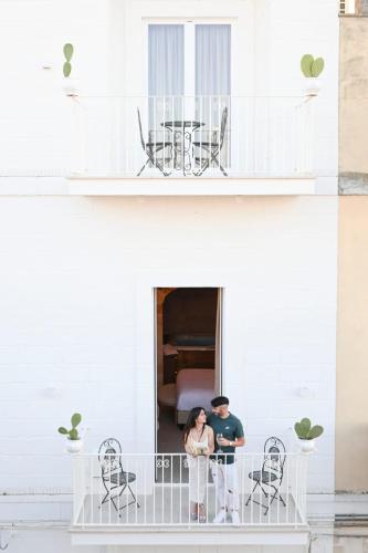a couple standing on the balcony of a house at DIMORA BIANCA in Triggianello