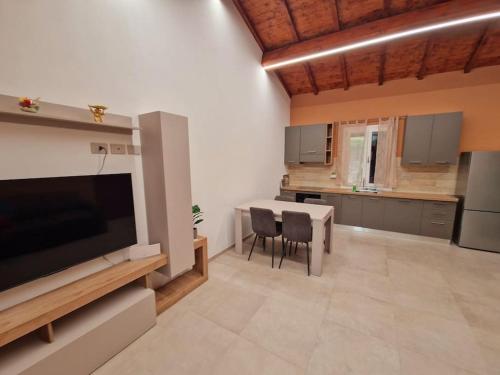 a kitchen with a large television and a table and chairs at Appartamento Ombra in Pontassieve