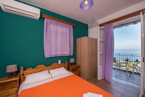 a bedroom with an orange bed and a balcony at Elena Studios in Athani