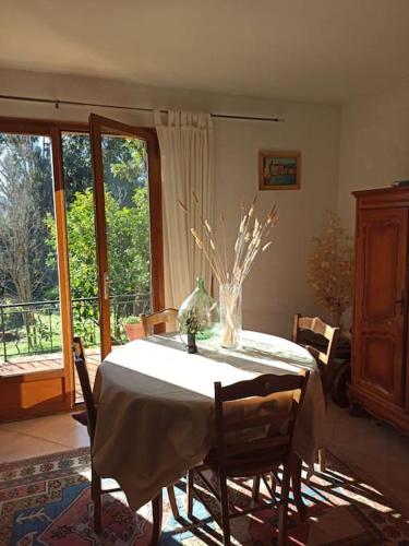 une salle à manger avec une table avec un vase dessus dans l'établissement Villa avec grand jardin au centre de St Florent, à Saint-Florent