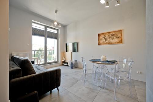 salon ze stołem i krzesłami w obiekcie Wygodny apartament w Pucku w mieście Puck