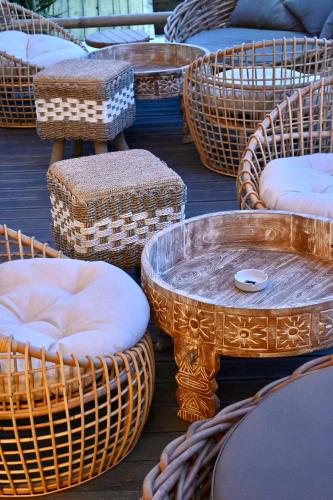 a group of wicker chairs and tables on a deck at Royal G Max in Golem
