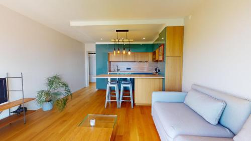 un salon avec un canapé et une cuisine dans l'établissement Le Refuge du Marin, à Saint-Gilles-Croix-de-Vie