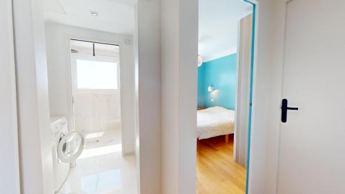 - une salle de bains avec toilettes et un lit dans une chambre dans l'établissement Le Refuge du Marin, à Saint-Gilles-Croix-de-Vie