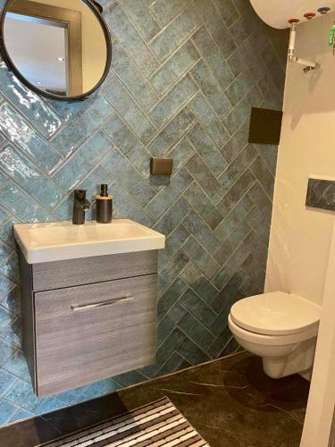 a bathroom with a sink and a toilet and a mirror at City apartment in Pärnu