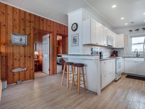 a kitchen with white cabinets and bar stools at Mamaws Spot in Hampstead