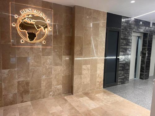 un hall d'un bâtiment avec un panneau sur le mur dans l'établissement Central Apartment Prishtina, à Pristina