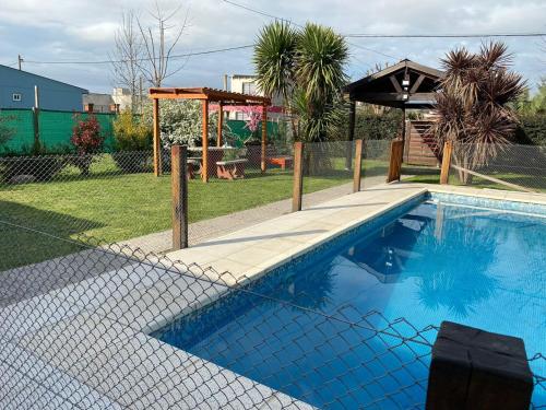 a swimming pool with a fence around it at El Quincho in San Miguel del Monte