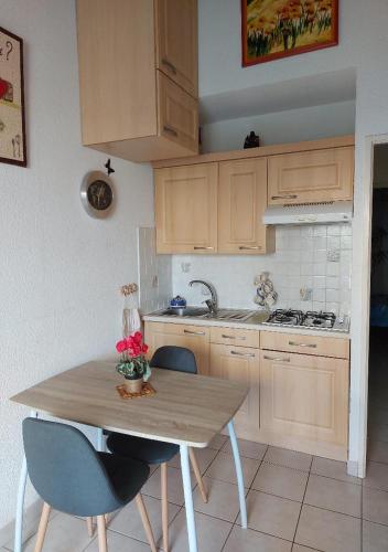 une cuisine avec une table en bois et deux chaises dans l'établissement Cap d'Agde, appartement bord de mer, 50 m plage de la Roquille, climatisé et WIFI,, au Cap d'Agde