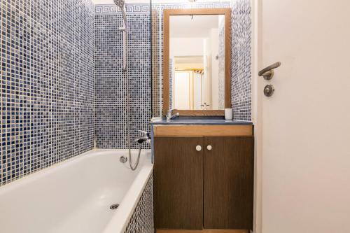 une salle de bain avec une baignoire, un lavabo et un miroir dans l'établissement Résidence le Hameau de Cap Esterel - maeva Home - Studio 4 personnes - Sélection MAE-9284, à Saint-Raphaël