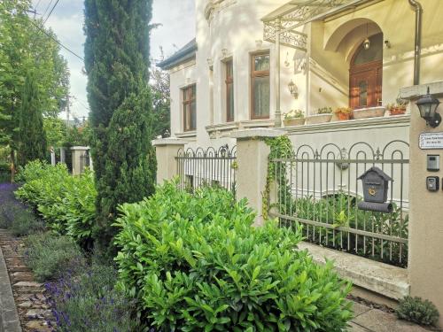 an old house with a fence and some bushes at Kúria Apartman Budapest with free parking in Budapest