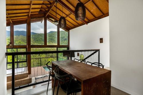 a dining room with a table and a large window at Lobo Guará - Refúgio romântico com vista incrível in Itatiaia
