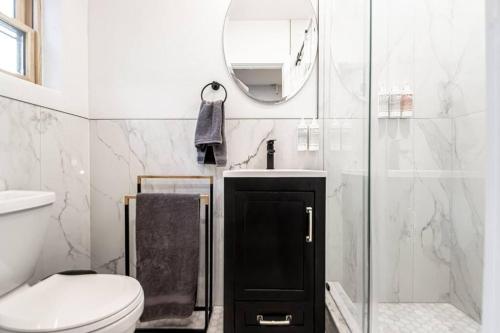 a bathroom with a toilet and a sink and a mirror at Walk to Bathhouses, Restaurants, Heart of Downtown, Room # 303 in Hot Springs