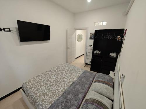 1 dormitorio con 1 cama y TV de pantalla plana en Ca' Barabino, en Génova