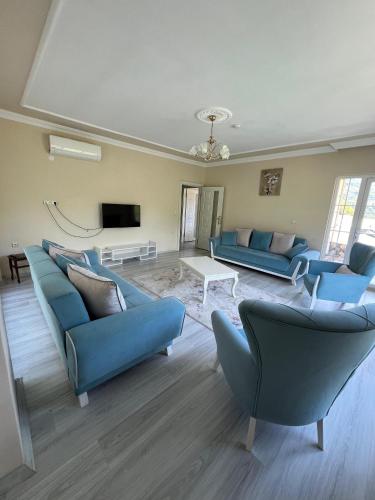 a living room with blue couches and a tv at Yavuz Luxury Apartments in Macka