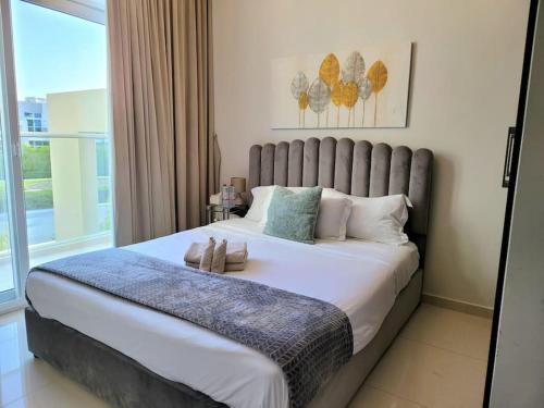 a bedroom with a large bed with a large window at Damac Hills 2 Retreat- Tranquil Luxe, Beyond City with waterpark in Dubai
