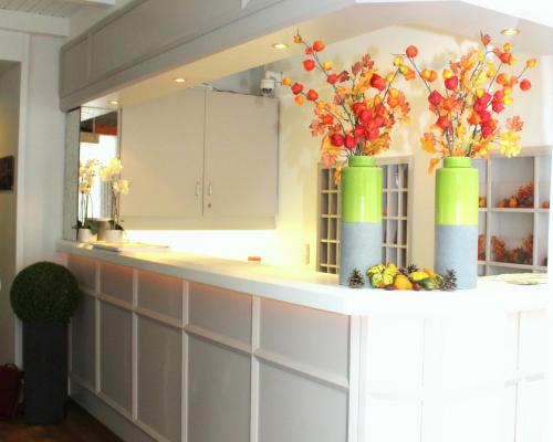 a kitchen with two vases with flowers on a counter at Hotel S16 in Munich