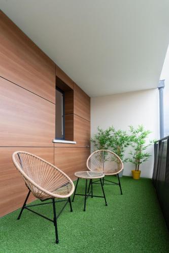 - 2 chaises et une table dans une chambre dotée d'une moquette verte dans l'établissement Le Rubens - Appartement 2 chambres - 6 personnes - Parking - Métro, à Toulouse