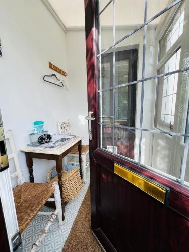 a door leading into a room with a table at Holly Cottage Cosy Home In Sherwood Forest in Edwinstowe