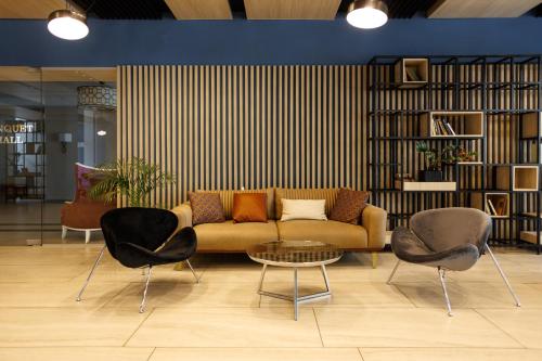 a living room with a couch and two chairs at Park Hotel in Tiraspol