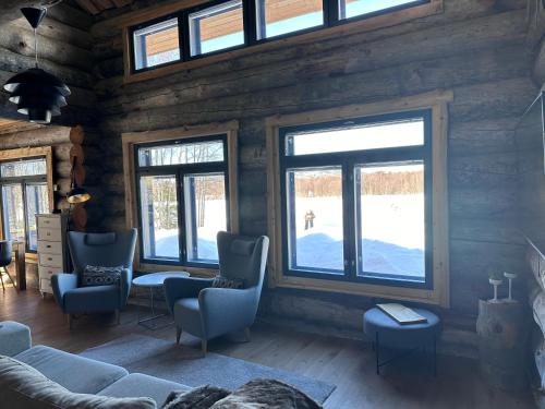 a living room with windows in a log cabin at Villa Karhukumpu in Ivalo