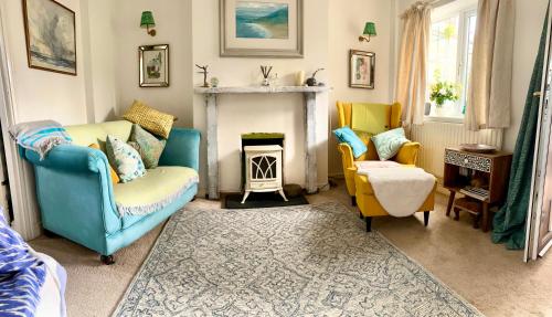 a living room with two chairs and a fireplace at Holly Cottage Cosy Home In Sherwood Forest in Edwinstowe