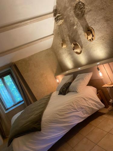 a bedroom with a bed in a small room at Moulin de l’Arcas in Prémian