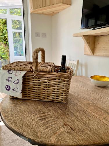 a wicker basket sitting on top of a table at Holly Cottage Cosy Home In Sherwood Forest in Edwinstowe