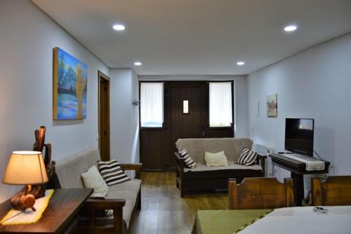 a living room with a couch and a piano at Casa da Fonte in Pitões das Júnias