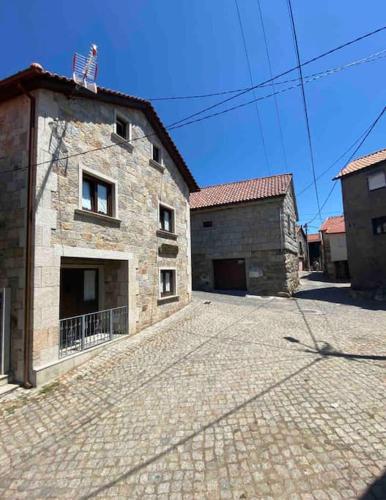 a large stone building on a brick road at Casa da Fonte in Pitões das Júnias