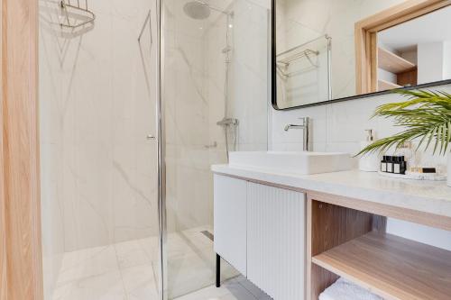 a white bathroom with a shower and a sink at Atik Hotel Vienna in Vienna