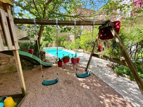 une balançoire avec des plantes en pot et une piscine dans l'établissement château - Le panoramique avec piscine, à Cumiés