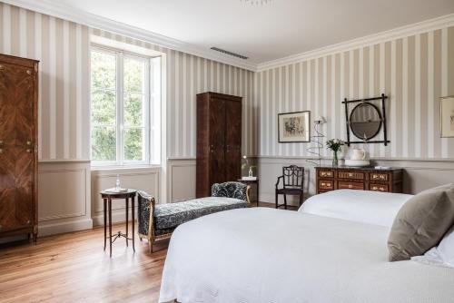 a bedroom with two beds and a desk at Château Sénéjac in Le Pian-Médoc
