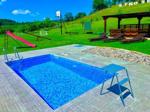 une piscine avec un toboggan et une aire de jeux dans l'établissement Etno selo Stanojevic, à Boljevac