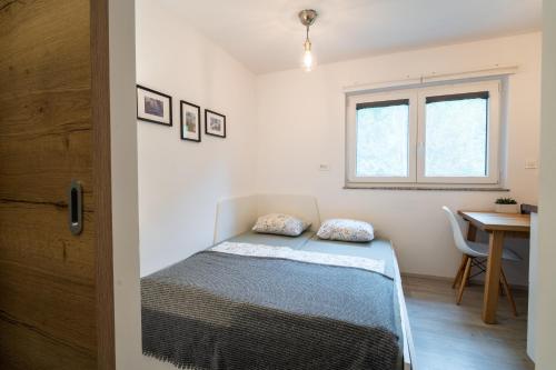 una camera da letto con un letto, una scrivania e una finestra di Apartment Loyd, Kranjska Gora - studio a Kranjska Gora