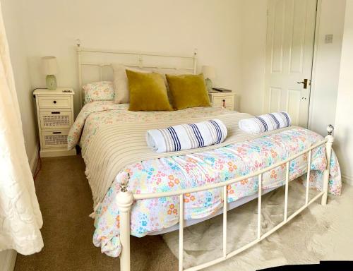 a bedroom with a large white bed with pillows at Unique Cosy Cottage In Sherwood Forest in Edwinstowe