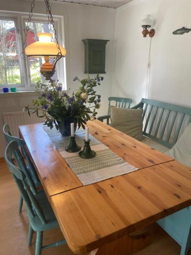 a wooden dining room table with flowers on it at Yngsjö, Aspvägen in Yngsjö