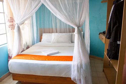 a bedroom with a bed with a mosquito net at Hummingcage in Nairobi