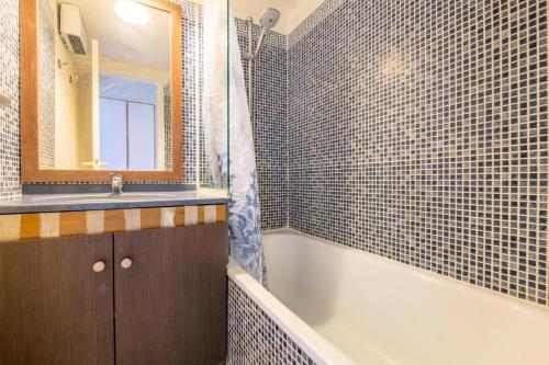 une salle de bain avec une baignoire, un lavabo et un miroir dans l'établissement Résidence le Hameau de Cap Esterel - maeva Home - Appartement 2 pièces 5 personnes - Sélection MAE-3081, à Saint-Raphaël